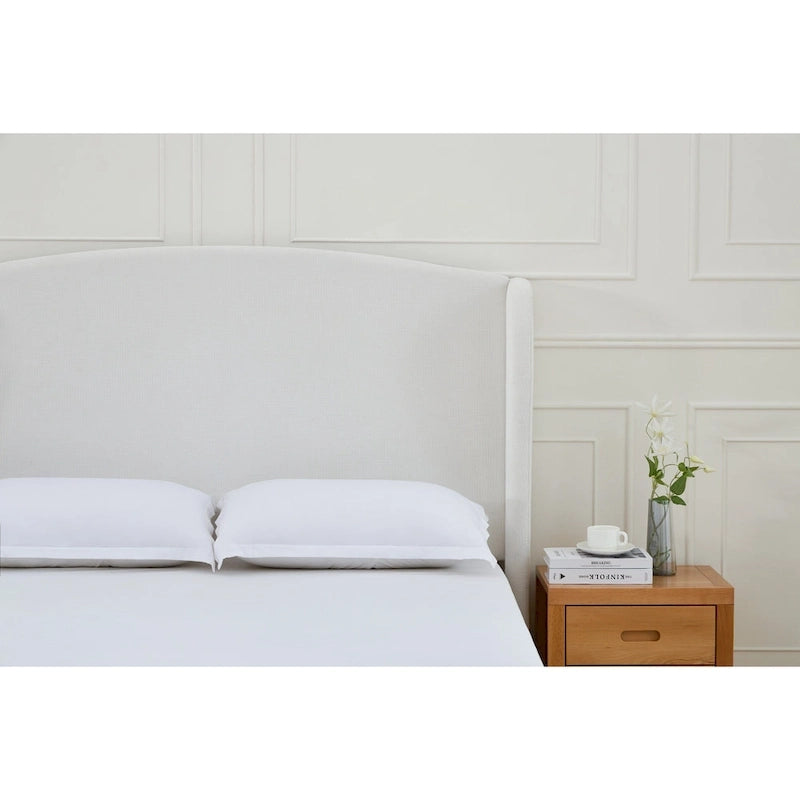 Letto a piattaforma imbottito con testiera ad ali e gambe in noce